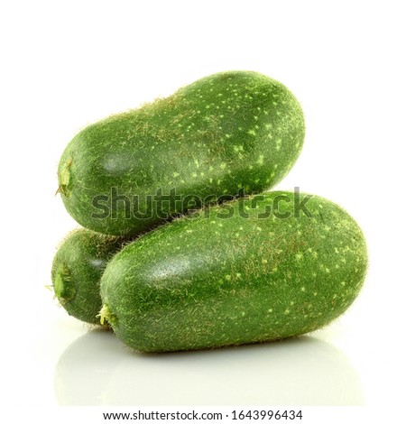 Three green zucchini on a white background