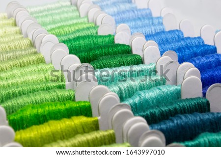 Colorful embroidery floss cross stitch string kit prewound on bobbins for crafts and hobbies. Multicolor thread on cardboard.  Royalty-Free Stock Photo #1643997010