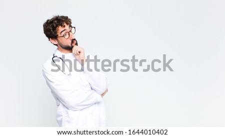 young crazy bearded doctor man against copy space wall