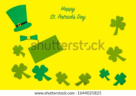 St. Patrick's Day in Ireland. flat lay green top hat, clover leaves, shamrocks on yellow background with copy space, text. Irish tradition, symbol. soft focus