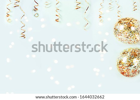 Gold serpentine and balloons with colorful confetti on shiny bokeh lights on festive background. Holiday decoration for parties, birthday, greeting card with copy space