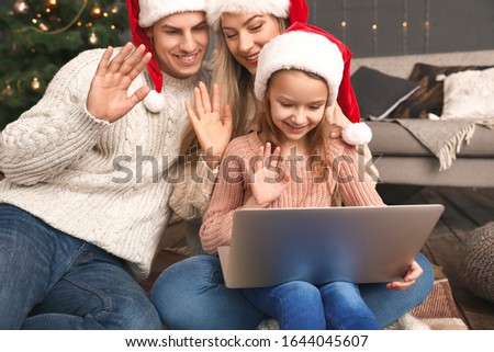 Happy family with laptop on Christmas eve at home