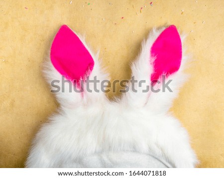 Plushy toy bunny rabbit ears. Happy easter concept. Yellow background. Easter minimal concept Picture with space for your text, top view