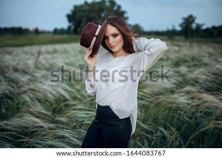 Red-haired girl in freckles puts on a hat