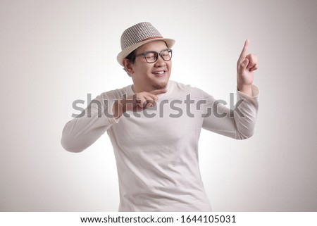 Portrait of a funny young Asian man smiling and dancing happily, joyful expressing celebrating good news victory winning success gesture