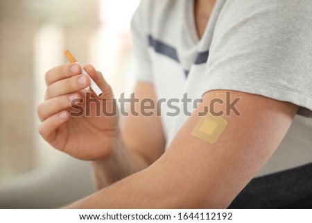 Man with nicotine patch and cigarette, closeup Royalty-Free Stock Photo #1644112192