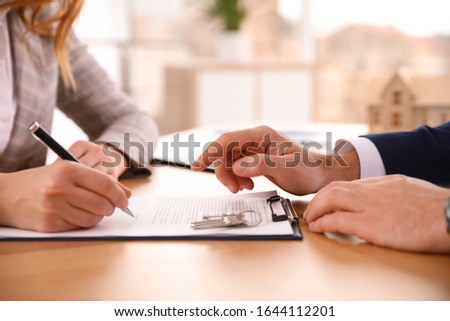 Real estate agent working with client in office, closeup