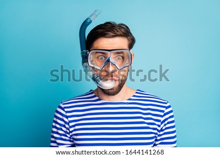 Photo of funky emotional handsome guy tourist diving underwater mask see colorful fish corals breathing tube floating deep wear striped sailor shirt isolated blue color background