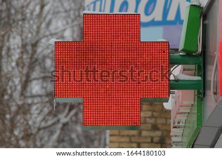 Red LED cross on outdoors, symbol of health and pharmacy products. Stock photo with empty space for text. 