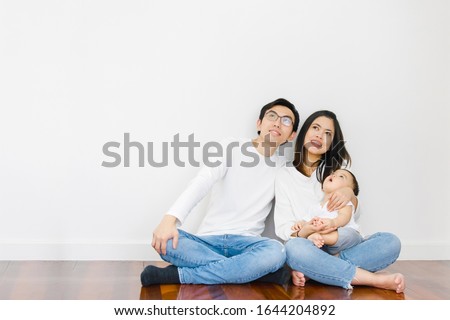 Asian families consist of parents and babies. Sitting on the floor of the house And looked up at the ceiling . Concept dream about future planning
