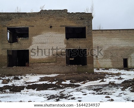 old ruined brick building with broken windows outside view in winter season