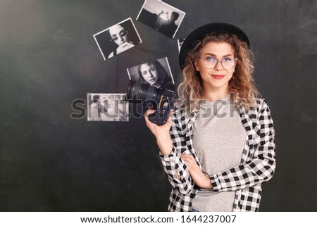 Young photographer with camera in studio