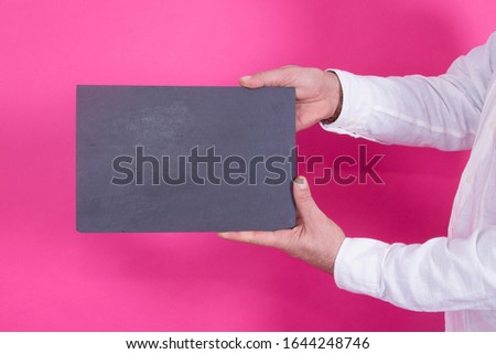 man holding empty poster on pink background