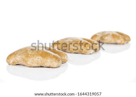 Group of three whole sweet brown gingerbread placed diagonally isolated on white background