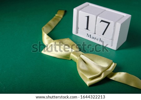 Wooden calendar with the date March 17, St. Patrick's Day, green butterfly