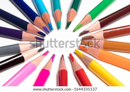 colored pencils laid out by the sun on a white background