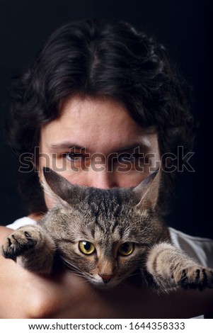 Cute tabby cat with beautiful girl on a black background