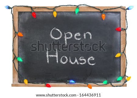 Open House written in white chalk on a black chalkboard surrounded with colored lights isolated on white