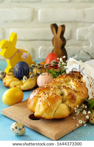 Traditional Italian Easter bread rings. Easter sweet bread with colored eggs on a blue stone concrete tabletop. Copy space.