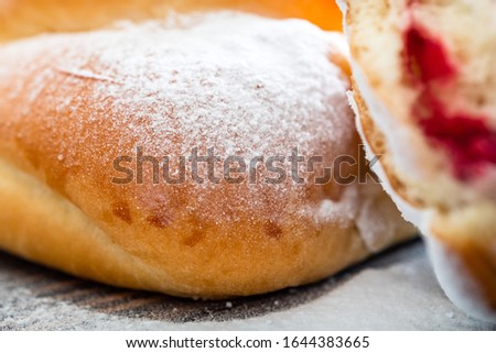 Fresh and rosy buns with cherry on a wooden table