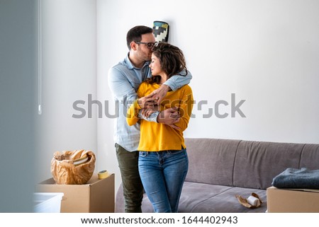 This place is a dream come true stock photo.Excited husband and wife kissing and hugging in living room feel overjoyed on moving day