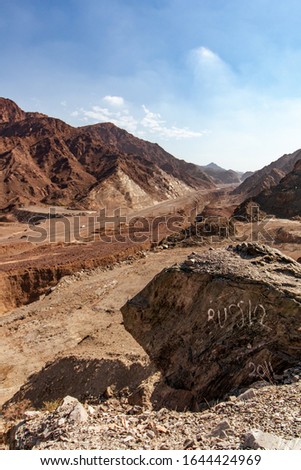 The mountain region of Fujairah, in United Arab Emirates, and the word "Russia" written on a stone.