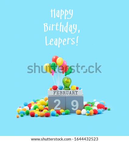 Happy Birthday, Leapers - greeting card. February 29 date calendar, Frog toy, festive decor, balloons on blue background. leap day in leap year concept.