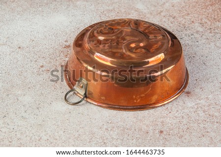 Vintage copper cake mold close up on a concrete background. Copy space for text.
