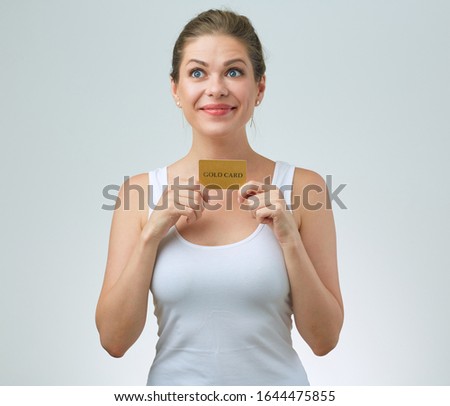 Happy woman in white sporty t shirt holding credit card. isolated female portrait.