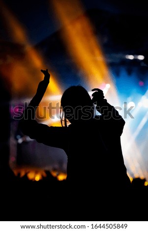 Music fan enjoying night perfomance of famous artist on stage.