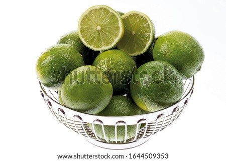 Limes in a chrome-plated fruit bowl