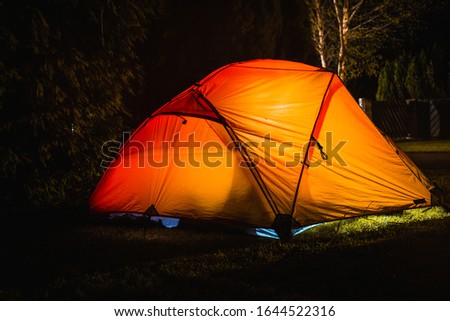 Lighted tent at a campsite at night