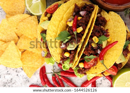 Mexican tacos with beef, tomatoes, avocado, chilli and onions 