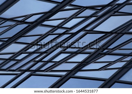 Double exposure of glass facade wall panels. Low angle photo of multistory office building. Modern business architecture. Urban corporate real estate. Polygonal windows geometric background.