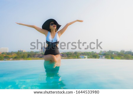 Portrait beautiful young asian woman happy smile relax around outdoor swimming pool in hotel resort for travel vacation