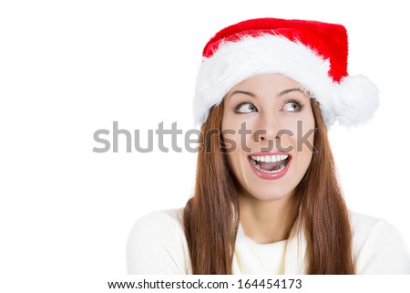 Closeup portrait of a beautiful happy young santa girl helper in red hat, looking sideways dreaming about gifts, holidays, isolated on a white background. Positive human emotions, facial expressions
