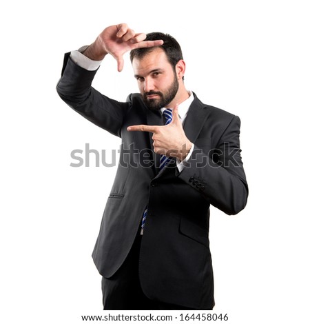 Young businessman doing a frame sign over white background