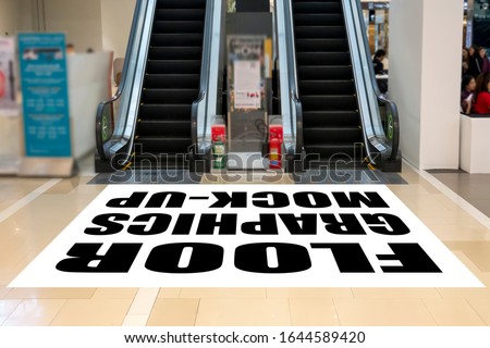 Mock up perspective blank horizontal screen on floor with clipping path at front of escalator in shopping mall, empty space for insert graphic or text information or warning word