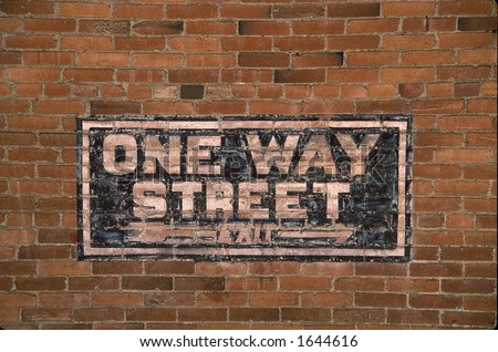 One Way street sign painted on old downtown building.