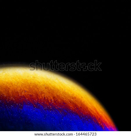 Close up of colorful soap bubble abstract over black background