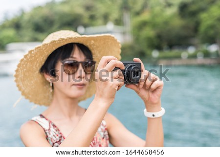 traveling Asian woman with hat take a pictures at Sun Moon Lake, Taiwan