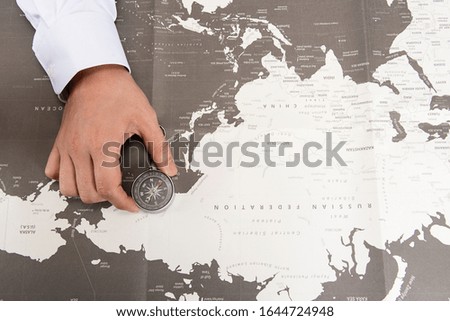 Business man sees map using compass on world map