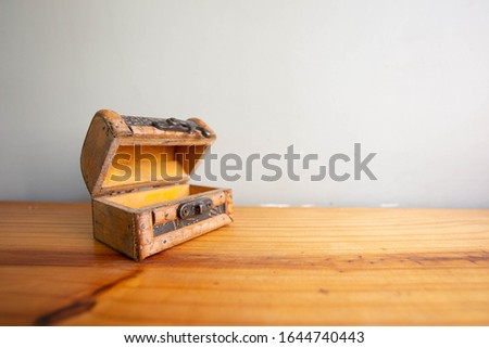 wood vintage old treasure chest opened on wooden table and gray wall