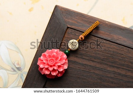 Pink shell key chain in the shape of peony.The Chinese character in the picture means:  Blessing.