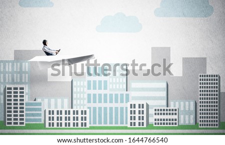 Businessman in aviator hat sitting in paper plane and holding steering wheel. Happy pilot driving paper plane on background of cartoon business center with high skyscrapers and office buildings.