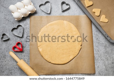 Process of making homemade cookies for St. Valentines Day on grey stone table. View from above.