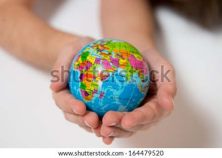 Little Kid holding World Globe on her Hands isolated on white background