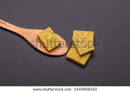 Vegetable bouillon stock or broth cube on wooden spoon