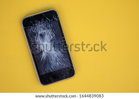 Cracked screen on mobile phone against colorful background