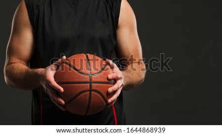 Front view of basketball held by male player with copy space 